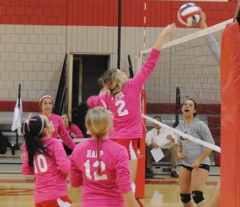 Junior Hannah Fehir jumps high off the ground to hit the ball over the net during the “Pink Out” game against Ambridge on Oct. 8 at FHS.