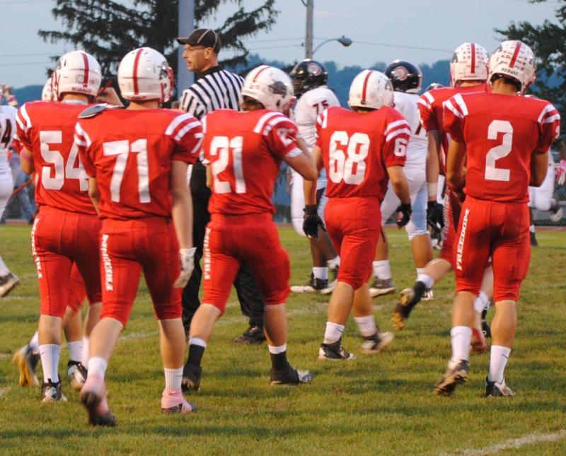 The football team walks back onto the field after taking a brief break during a quarter.