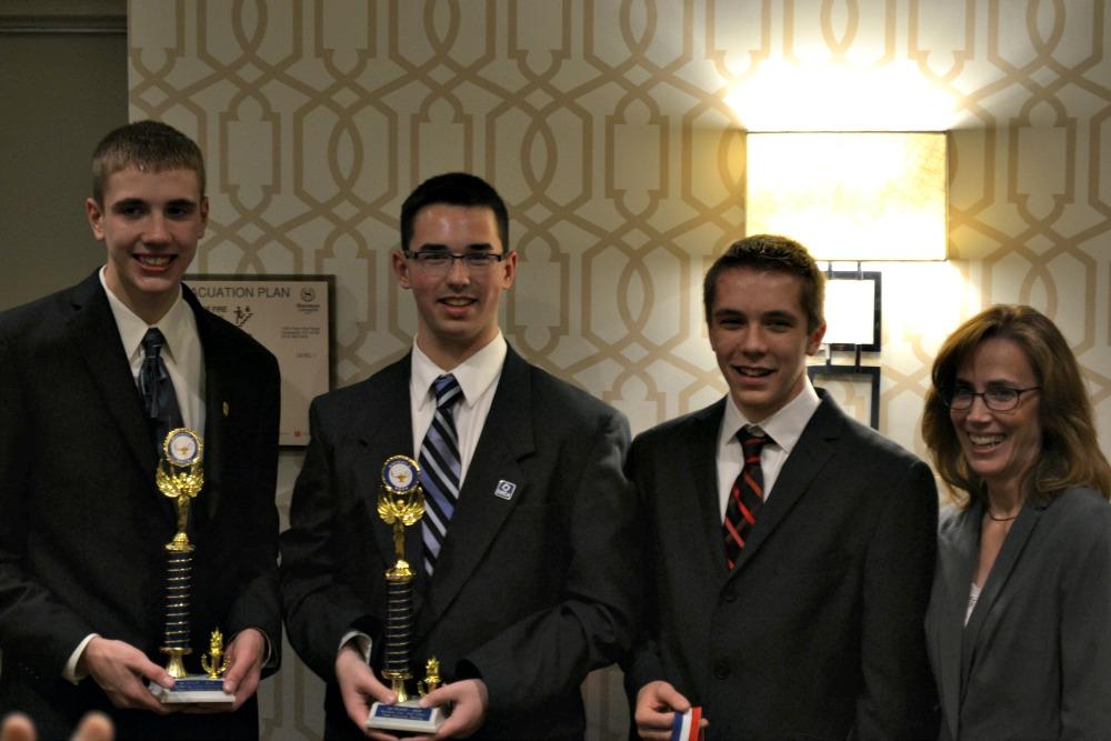 Junior Zach Kugel and Sophomores Dereck Majors and Levi Bonzo stand alongside advisor Mrs. Beth Majors after placing at district competition.