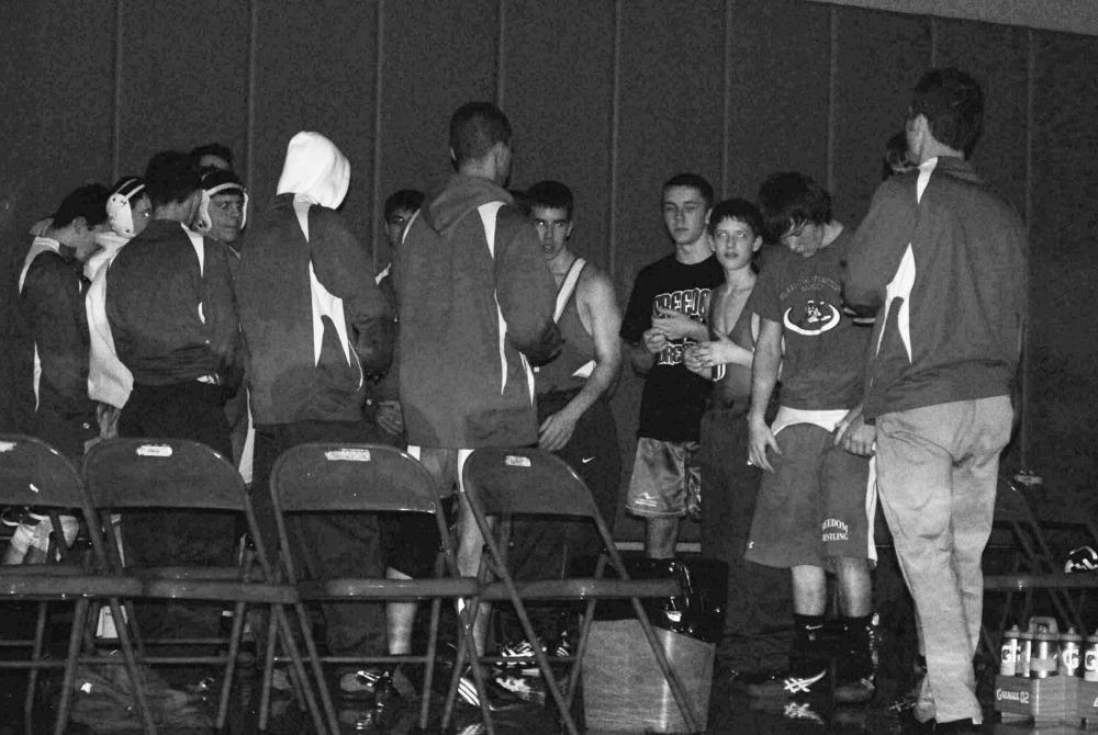 The varsity wrestling team stands in a tunnel formation to clap for the next wrestler at the first home match of the season on Dec. 11.
