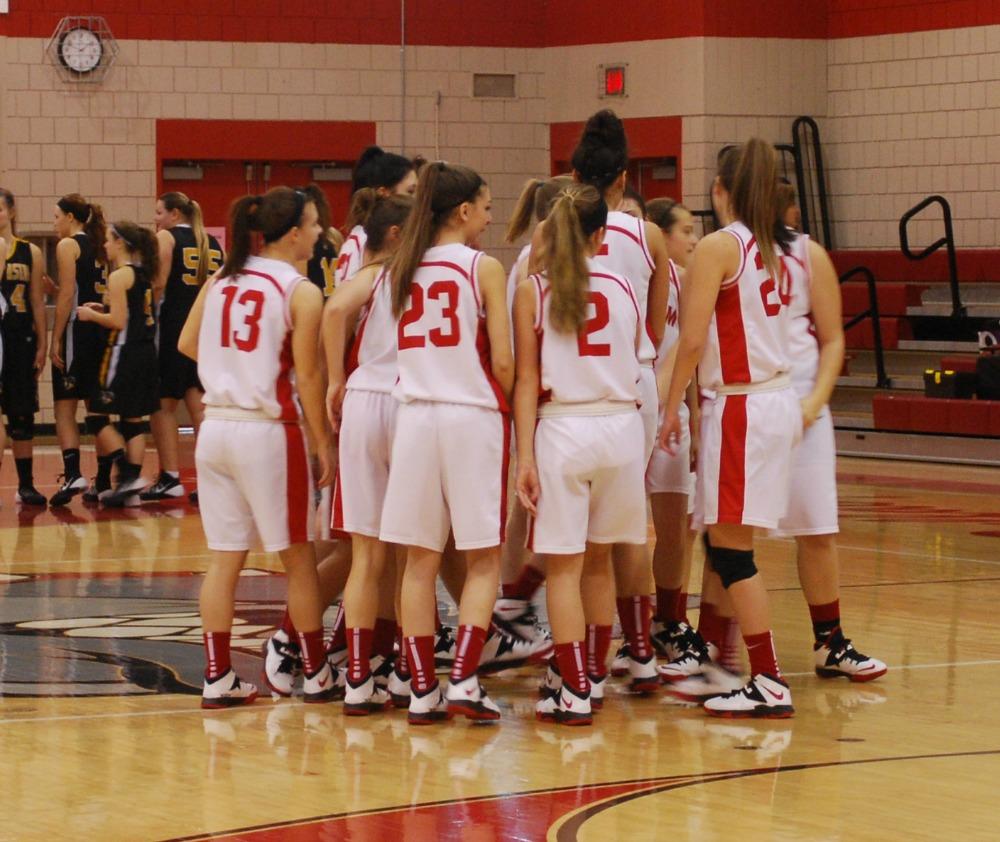 The girls' basketball team gathers in a huddle in a game against South...