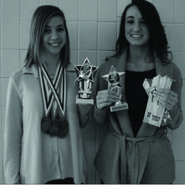 Sophomores Megan Scott and Rachel Mazzetti hold up their gymnastics trophies and ribbons.