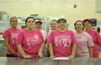 Cafeteria staff cooks and serves with cheer