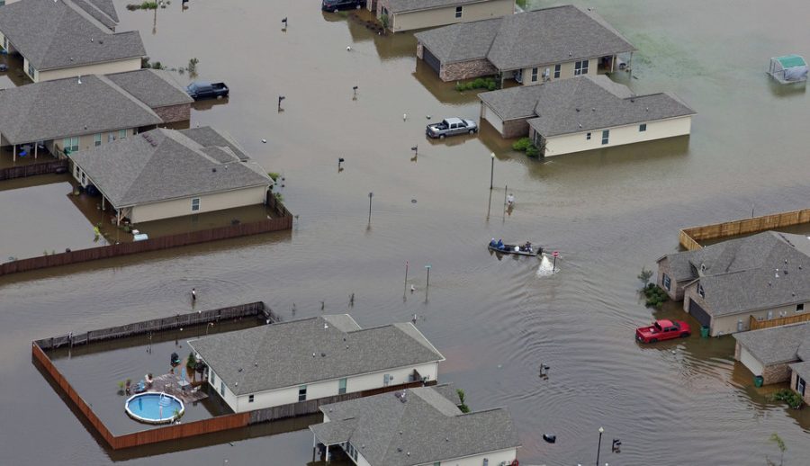 In this aerial photo a boat motors between flooded homes after heavy rains inundating the region Saturday, Aug. 13, 2016, in Hammond, La. Louisiana Gov. John Bel Edwards says more than 1,000 people in south Louisiana have been rescued from homes, vehicles and even clinging to trees as a slow-moving storm hammers the state with flooding. (AP Photo/Max Becherer)