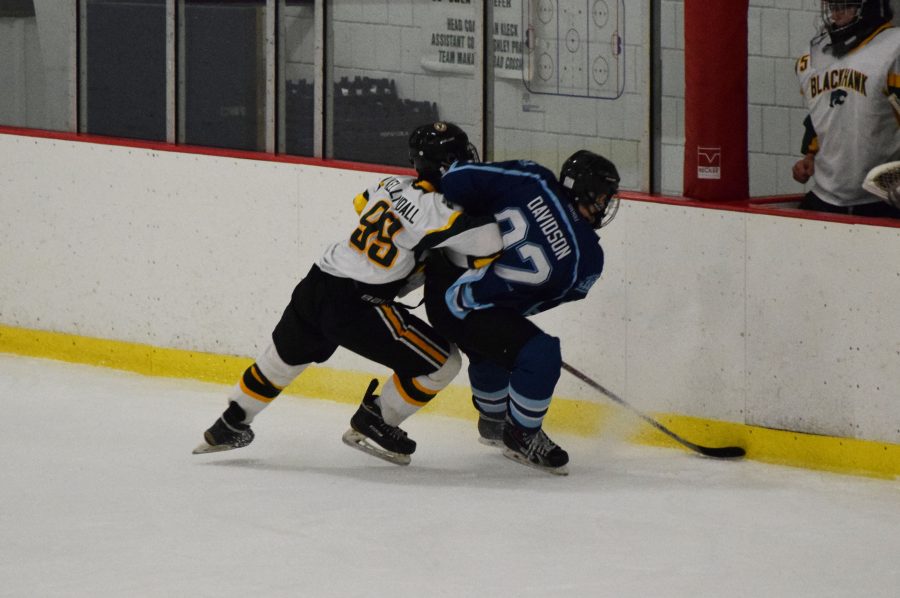 Junior Jimmy Kelly slams a player from Central Valley in the fight for the puck during the game on Oct. 27. Kelly is one of three players from Freedom who currently play on Blackhawk’s hockey team through a cooperative agreement.
