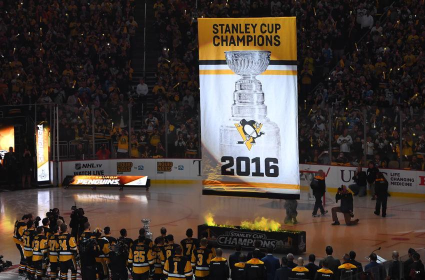 Penguins players and fans watch as the 2016 Championship banner is raised to the rafters 
