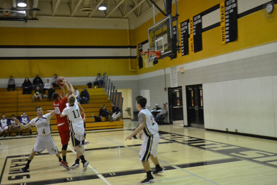 Senior Nick Henderson goes to shoot the ball while three opposing players attempt to block his shot.