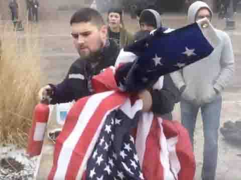  FedEx driver Matt Uhrin walks away from the scene of the protest with the fire extinguisher and two saved flags in hand. 