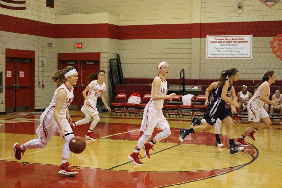  Freshman Myah Hrinko runs with the ball down the court.