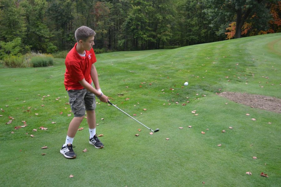 Sophomore Nolan Colaric Chips his Golf Ball towards the hole.