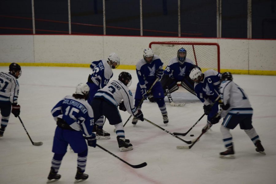 Junior Riley Adams faces three players from Connellsville on Dec. 14 as he makes his way towards the goal with the puck.