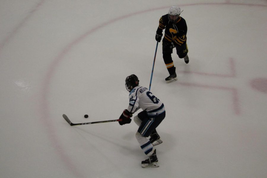 Senior Jimmy Kelly-Tindall skates around a defender with the puck in a game against Carrick.