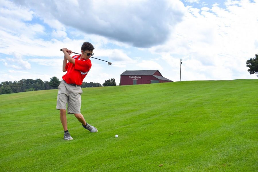 Sophomore Kameron Skrobacz pulls back his Four Hybrid to hit the ball on the North Course at Rolling Acres.