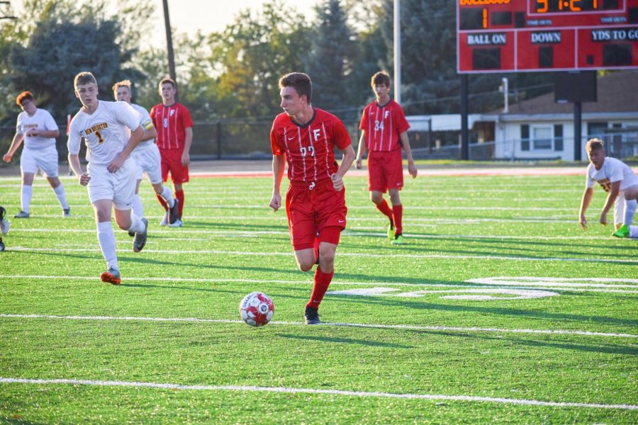 Senior Ethan Paxton looks to pass the ball as he runs down the field against New Brighton on Sept. 4.