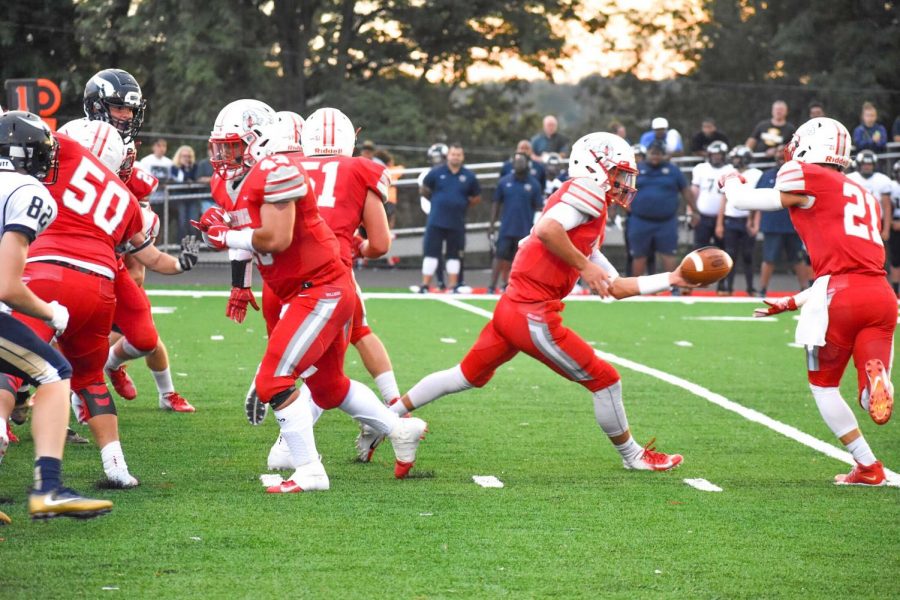 Senior Zach Rosa tosses the football to senior Jake Pail in attempt to get a first down. against Hopewell on August 24.