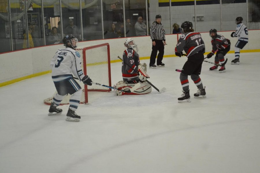 Senior Riley Adams (left) is shown waiting by the net for the puck in the hopes of scoring at the game on Oct. 18