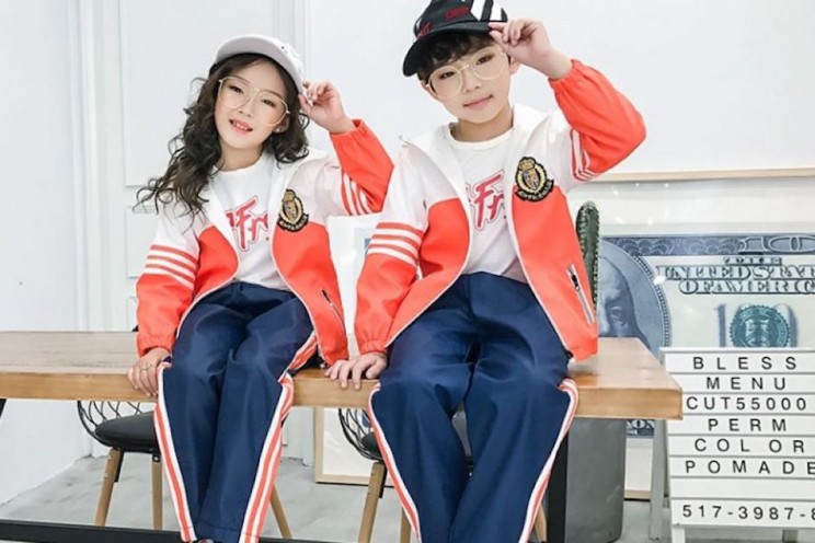Two children pose in the new smart uniforms that resemble tracksuits.