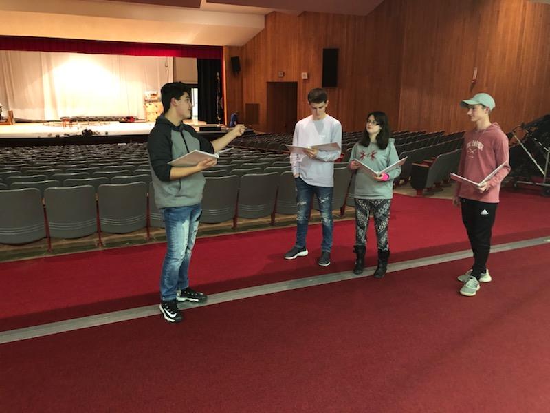 During a rehearsal on Jan. 16, juniors Mason Hedge, Casey Collins, Alyson Horner and freshman Jay Hessler go over their lines in the back of the auditorium. Hedge plays Gomez, while Collins, Horner and Hessler make up the members of the Beineke Family. 