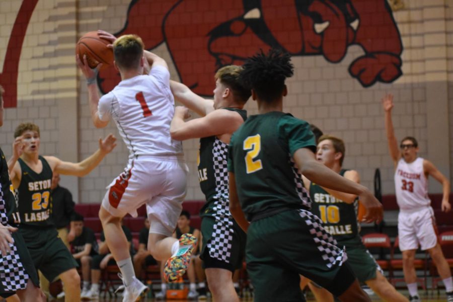 Junior Tyler Mohrbacher drives the paint and looks to pass the ball to senior Steven
Leasure for a three point attempt during their game against Seton LaSalle on Jan. 7. 