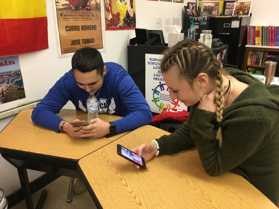 Juniors+Morgan+Swab+and+Brandon+Majors+use+their+phones+as+a+source+of+communication+on+February+19+at+the+end+of+their+Spanish+3+class.