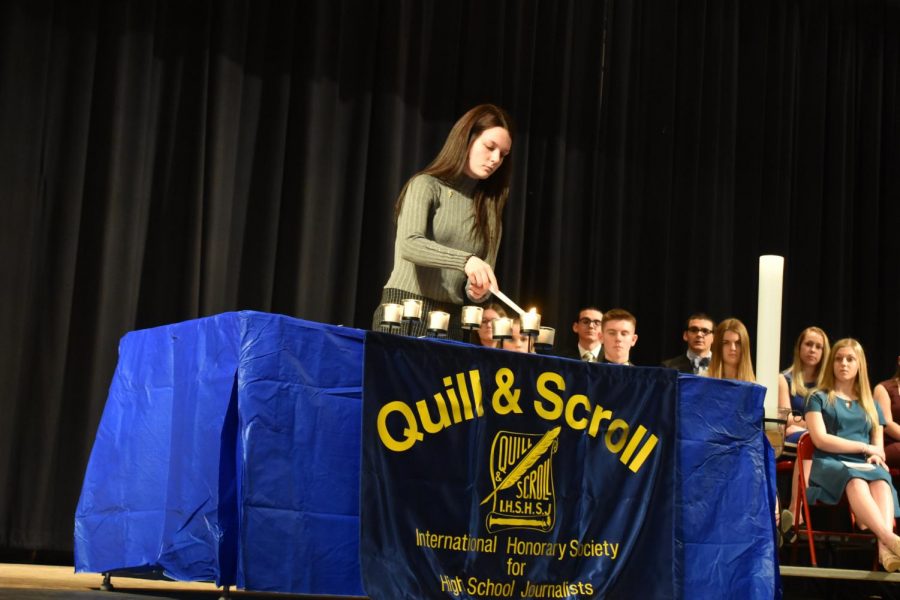  Lighting the candle of judgement, senior Claudia Huggins one of the six returning members starts off the induction ceremony.