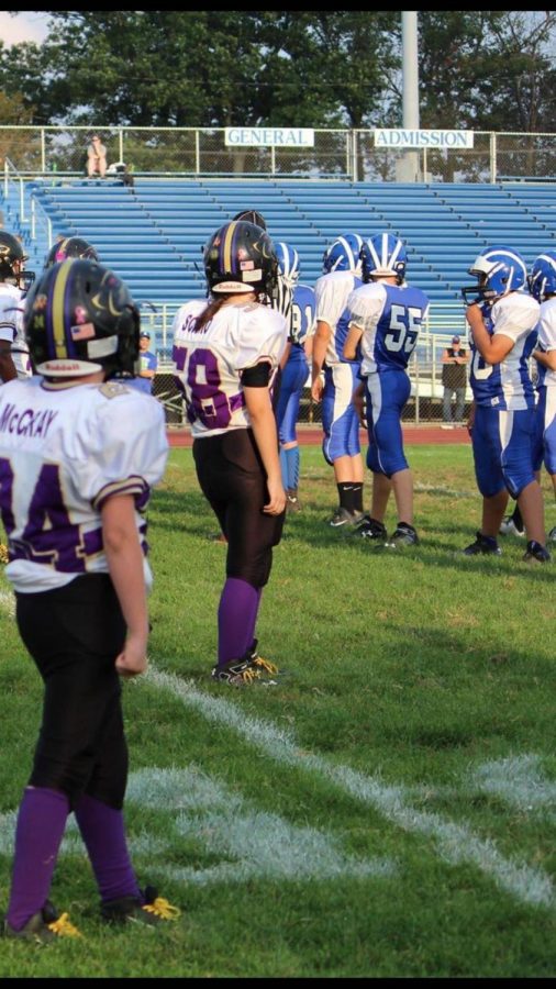 Senior Tabitha Scimio (number 58) takes the field with the rest of her football team before a game when she was in middle school.