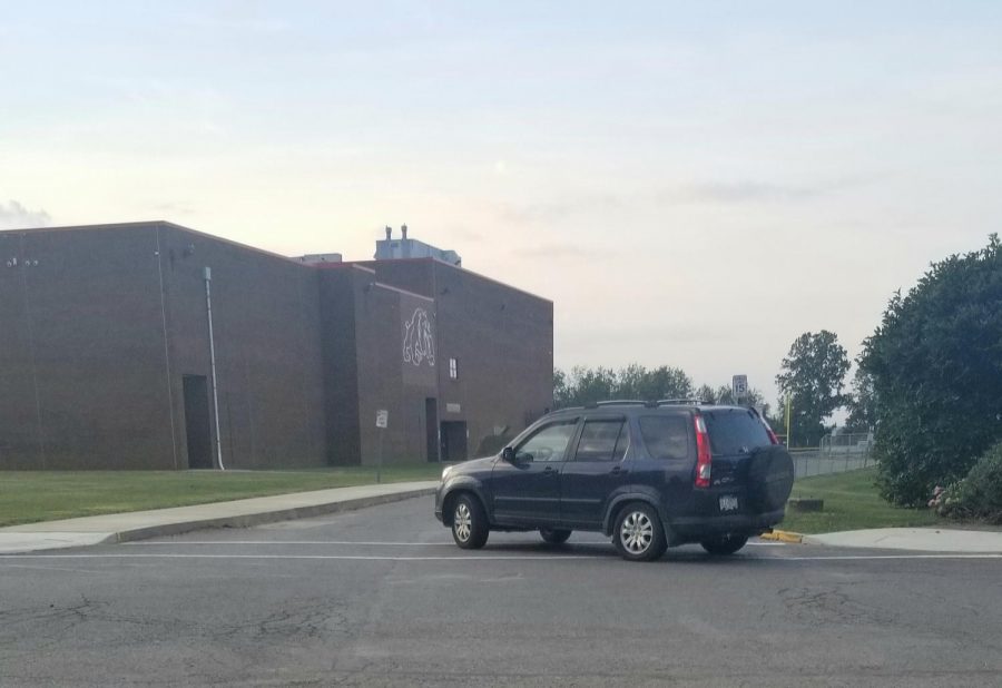  Heading towards the baseball field, a car makes a right by the bulldog statue as it follows the new morning drop off route that was implemented this school year. 
