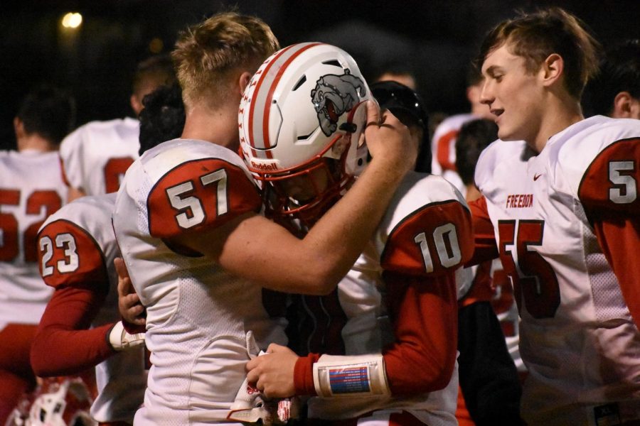  Seniors Kevin Lawrence and Dylan Goodrich hug after playing their last football game of their high school career, following their loss to Washington in the second round of playoffs. 
