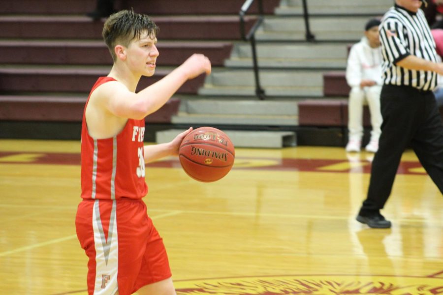 Senior Tyler Mohrbacher looks for open teammates to pass the ball to in an intense game against New Brighton on Jan. 14.