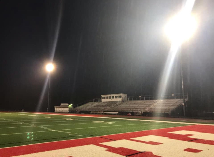 The Bulldog Stadium sits alone under the lights waiting for the upcoming fall sports to begin with players on the field and spectators in the stands.