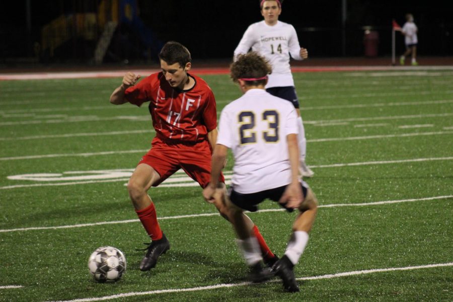 Junior Joseph Hartle takes on a Hopewell Viking defender to advance the ball up the
field on Oct. 12.