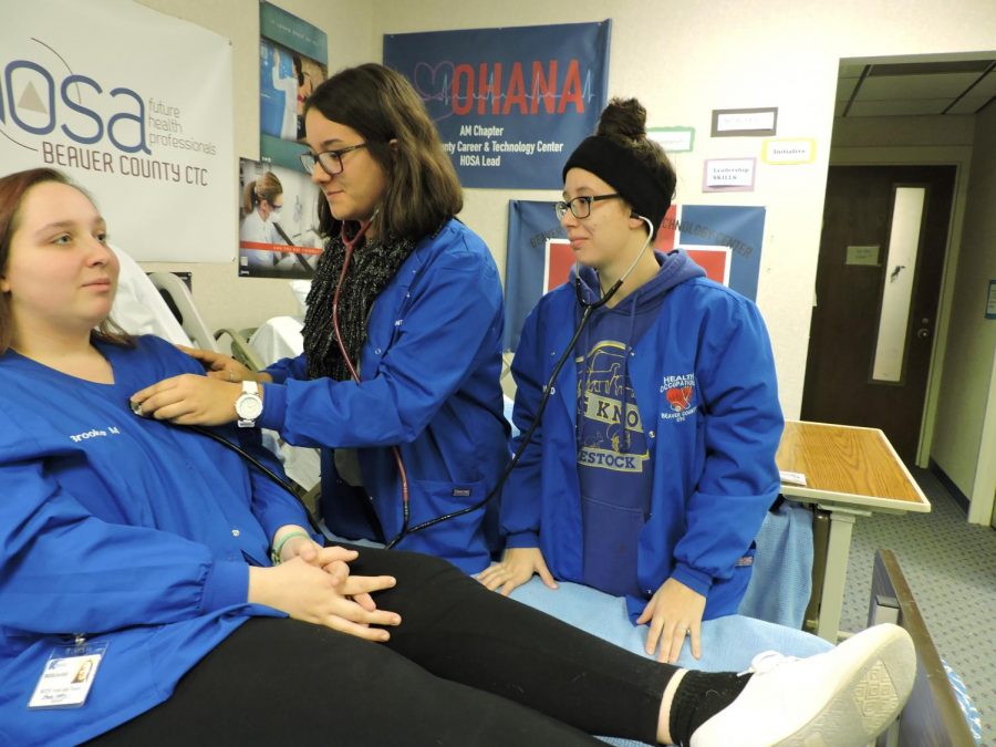 Three Freedom 2019 alumns practice using a stethoscope at the CTC.