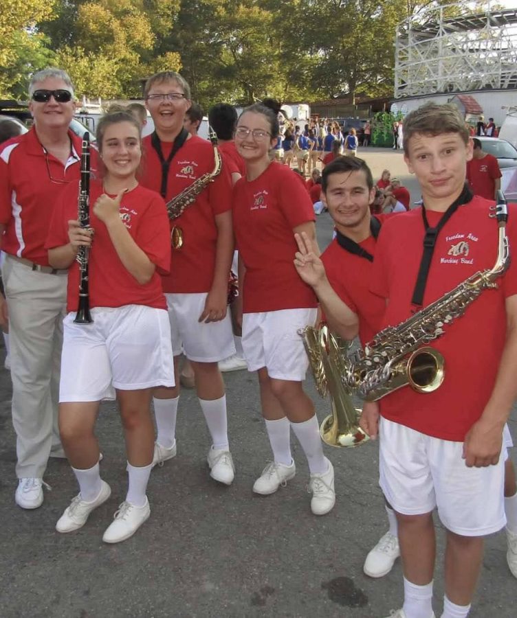 Band+director+Robert+James+poses+with+students+before+marching+at+the+Kennywood+parade+in+Aug.+of+2019.+