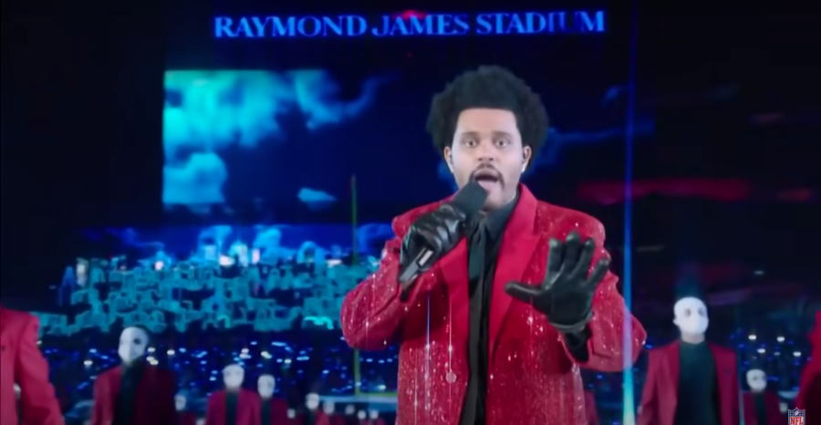 The+Weeknd%2C+surrounded+by+backup+dancers%2C+performed+Blinding+Lights+from+the+field+of+Raymond+James+Stadium+during+his+halftime+performance.