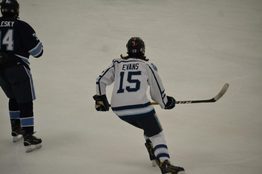 While skating across the ice, senior Marc Evans goes to try and hit the puck.