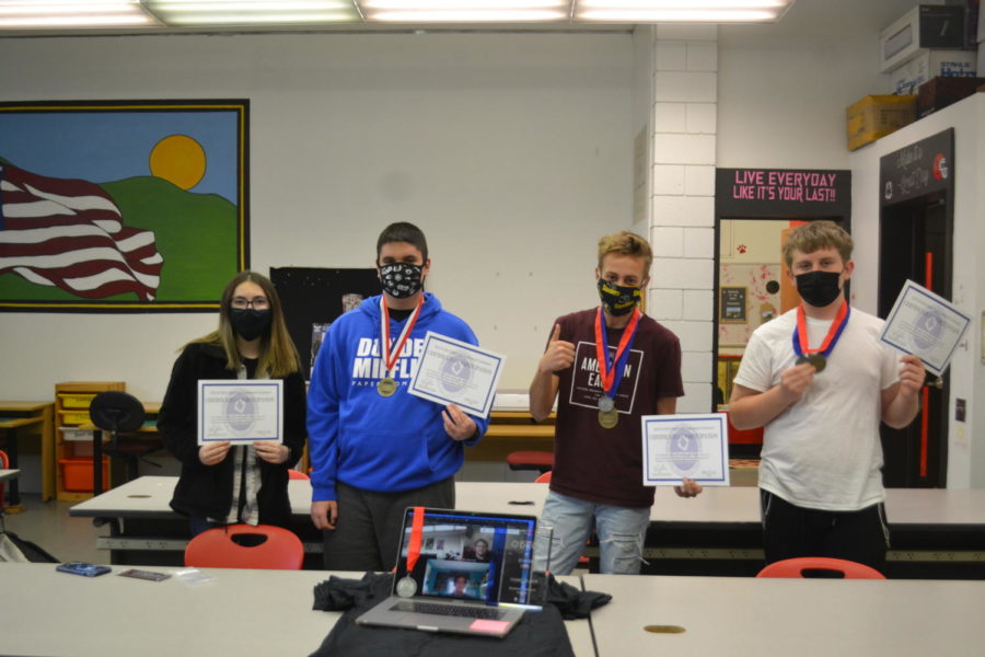 Standing proud, Skylar Scobbo, Anthony Battaglia, Luke Snavely, Connor Tavern and
fellow students online pose for a picture holding their certificates and medals from the PA DECA Championships.