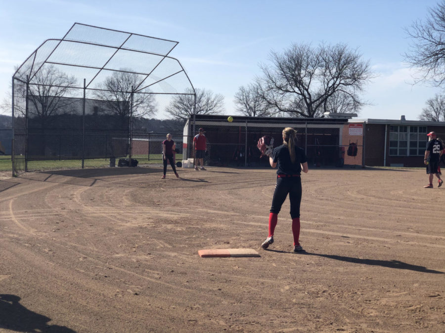 Senior Erica Gazdik makes a throw to freshman Shaye Bailey at first base during a practice on March 22.