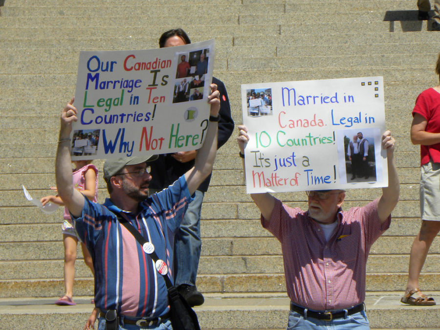 Activists stand outside a government house in Minnesota during a rally for LGBTQ+ rights, including same-sex marriage.