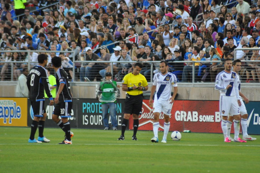 After calling a foul and giving a yellow card, the referee writes down the name of the guilty Los Angeles Galaxy player.