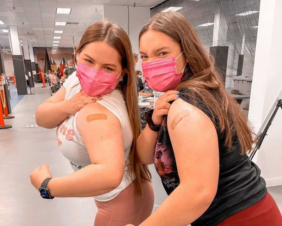 Juniors Alexis Rinere and Emily Frashure show off their arms after receiving the Pfizer-BioNTech vaccine on April 19.