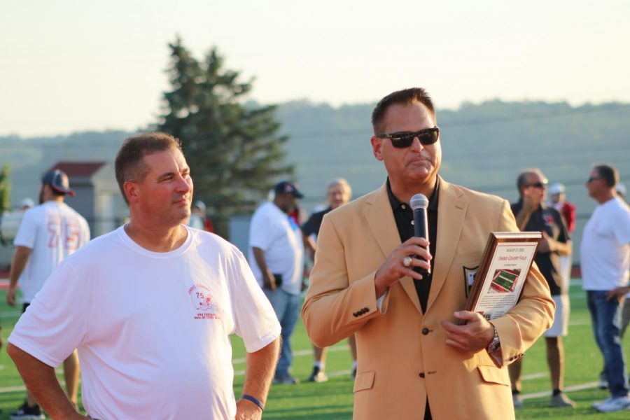 On August 27, Jimbo Covert stands with athletic director John Rosa as he is presented a plaque commemorating the field naming.  