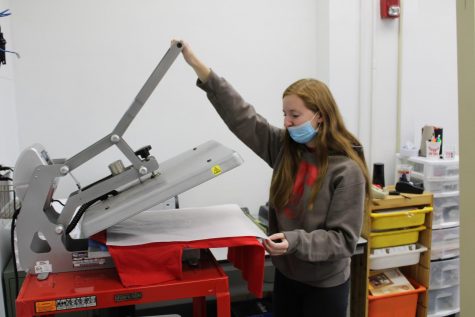 Senior Emily Young uses the heat press to make a shirt for the Powder-Puff game.