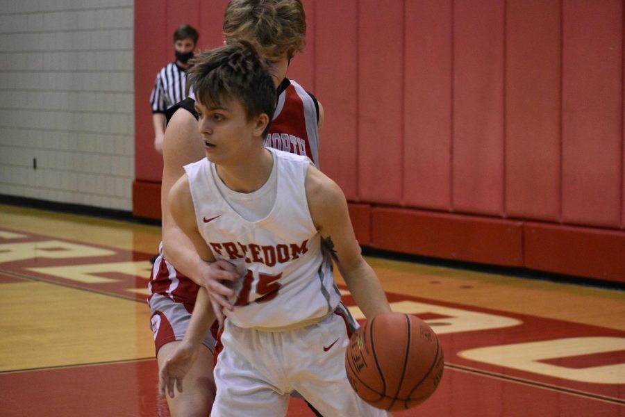 Then-junior Carter Huggins dribbles around an Avonworth defenseman and looks to pass the ball during a game on Feb. 9, 2021. 