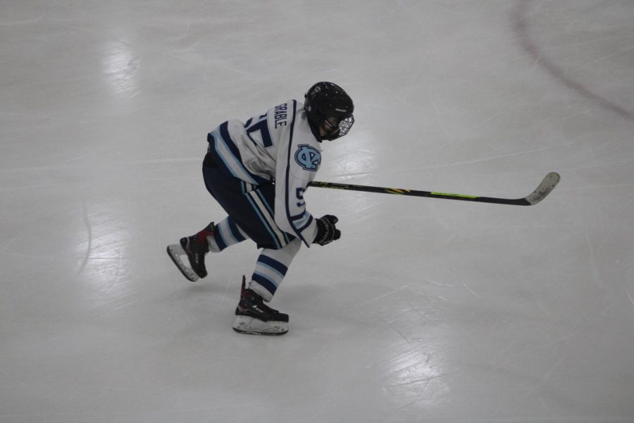 Skating towards the blue line, sophomore Chase Grable races for the puck as he plays against Wilmington on Dec. 7.