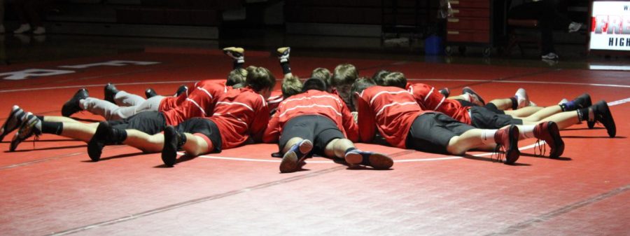 While preparing for their match against New Castle on Jan. 4, the boys lay on the mat together as they listen to a pep talk.
