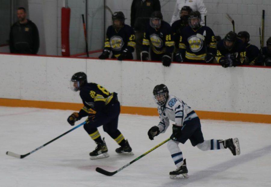 Sophomore Aiden Pournaras skates quickly with his eye on the puck during a game on Dec. 7, 2021.