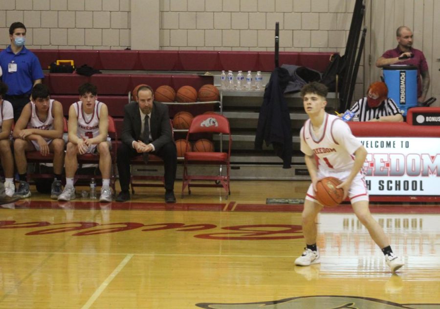 Holding the basketball, sophomore Logan Bickerstaff prepares to pass the ball to his teammate during Senior Night for the Bulldogs against Summit Academy on Feb. 7.