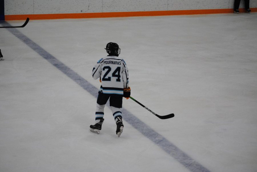 Looking for the hockey puck, sophomore Aiden Pournaras gets ready to skate towards his teammates and opponents.