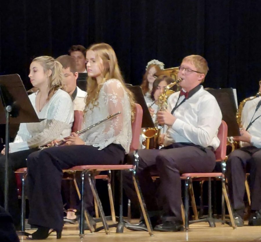 Ms.+Emily+Rickard%E2%80%99s+band+students+sit+on+stage+during+their+spring+concert+on+May+4.+The+flutes+rest+while+the+saxophones+play+along+to+the+melody.+