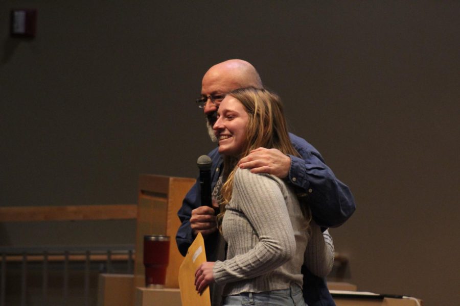 Still in shock, junior Megan Evans is congratulated by PSPA Contest Chair Paul Fantaski after winning the Editorial Cartoon contest at States on March 30. 